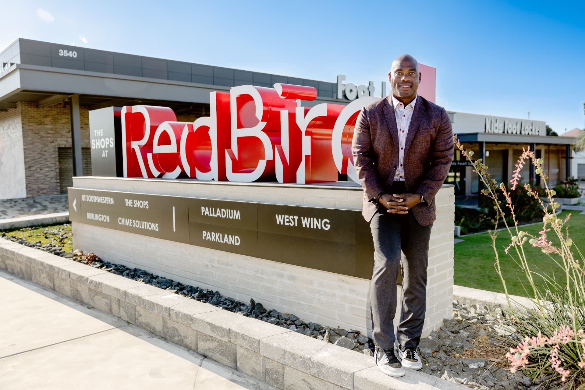 Terrence Maiden standing at The Shops at RedBird monument sign in Southern Dallas